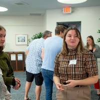 Scholar giving poster presentation to two guests.